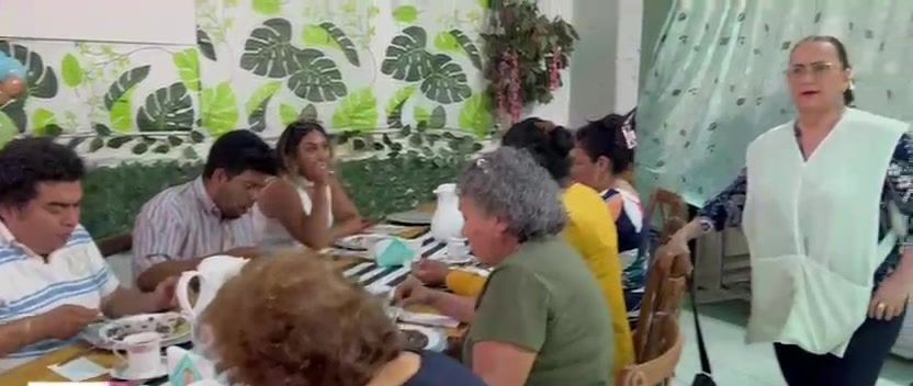 Personas comiendo en las mesas del comedor comunitario.