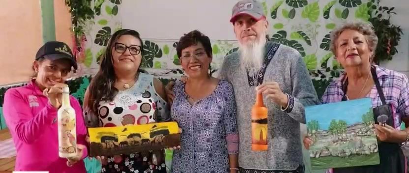 Alumnas y alumnos de un curso muestran sus trabajos: botellas decoradas, un cuadro y una caja pintada.